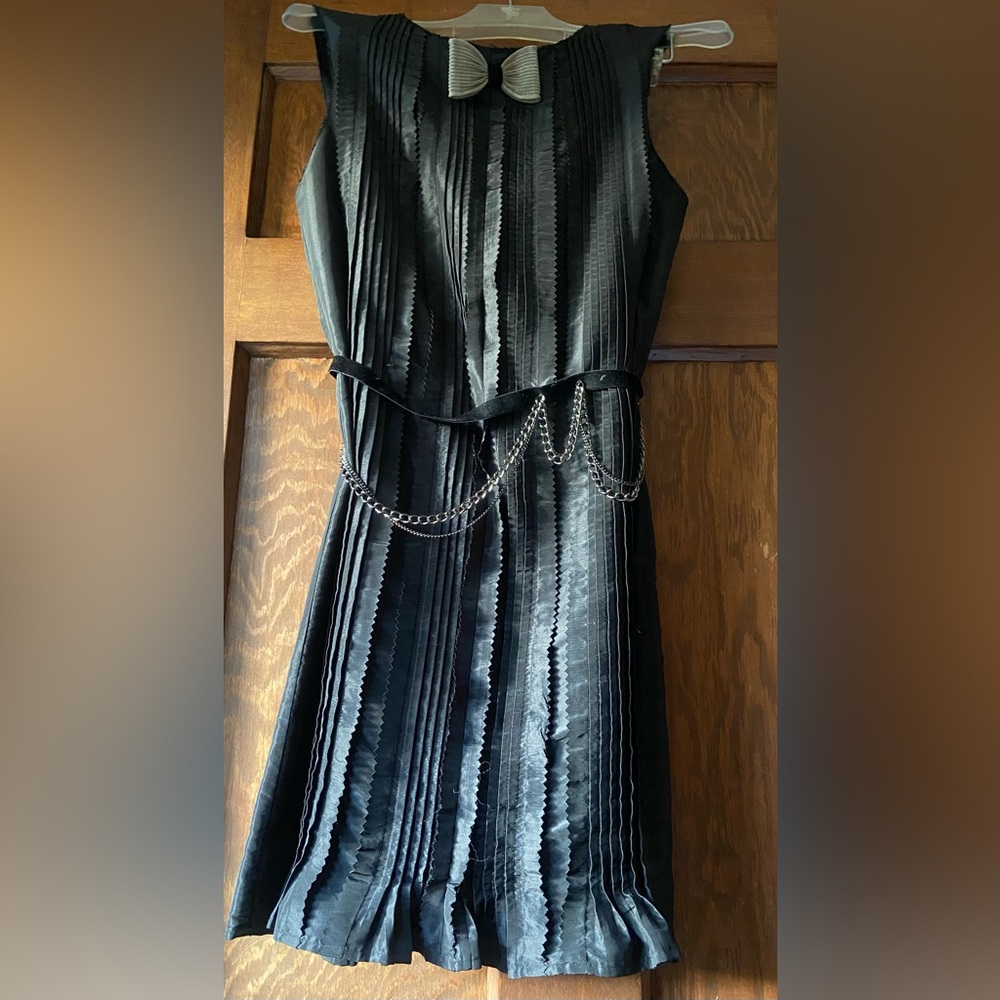 Julie Haus Elegant Black Pleated Cocktail Dress with Chain Detail.